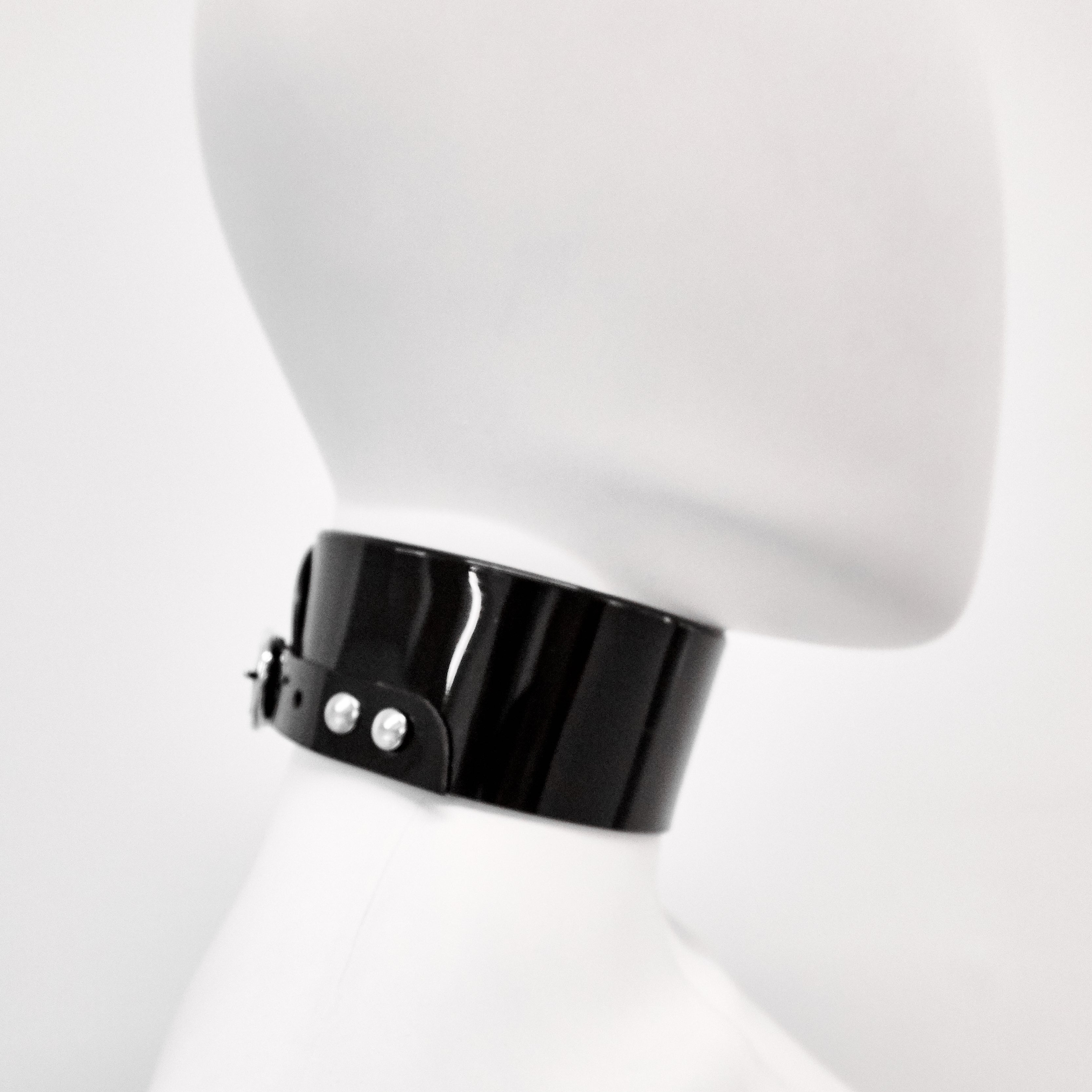 Jivomir Domoustchiev iconic vinyl chocker as seen in the Year and Years Sanctify video. available in a variety of colours. Simple yet striking adjustable for comfort. Finished with silver look studding & buckle. Complements any outfit.